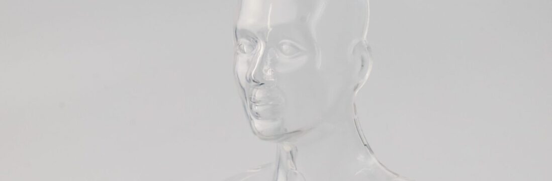 Image of a clear plastic mould of a human face and shoulders, on a white background.